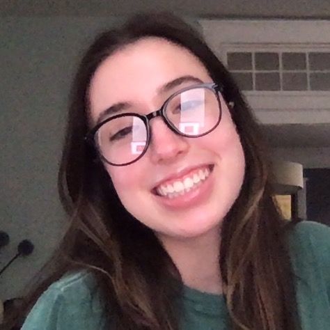 A diverse group of young adults jumping with excitement in a lush green garden during a community event.